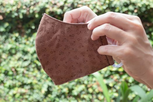 Woman shows self-made mask to protect against viruses and bacteria, stock photo