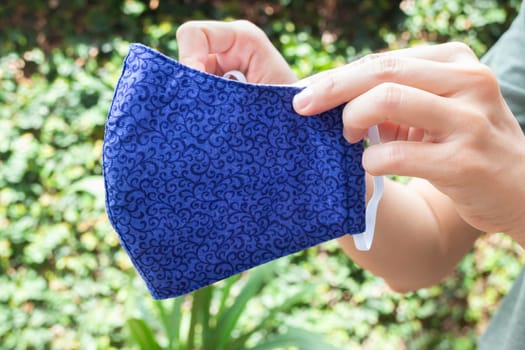 Woman shows self-made mask to protect against viruses and bacteria, stock photo