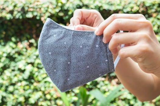 Woman shows self-made mask to protect against viruses and bacteria, stock photo