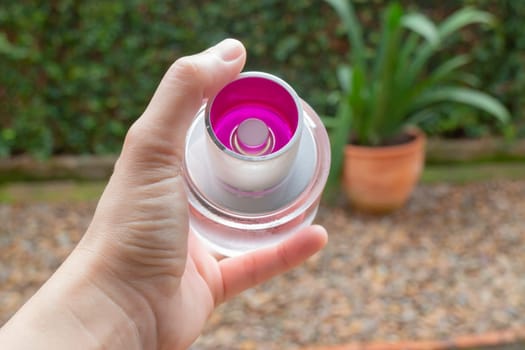Woman hand show and hold perfume bottle, stock photo