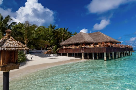 View to a bar on an island with clouds and beach