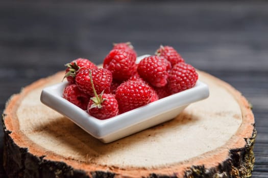 Fresh raspberry in a wooden plate