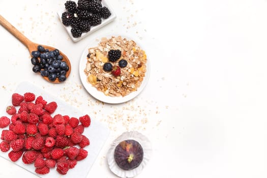 bowl of corn flakes with berries on white background
