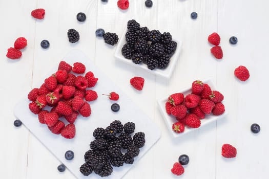 Blueberries, raspberries and blackberries on white background.
