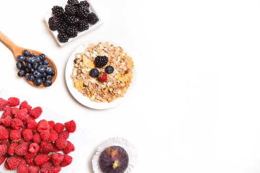 bowl of corn flakes with berries on white background