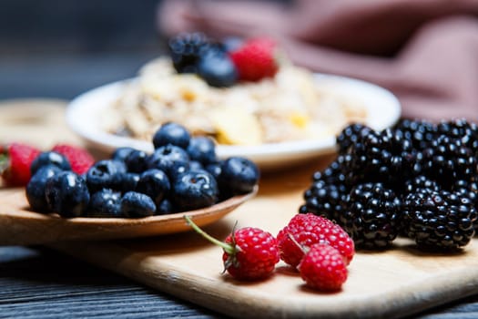 Berries mix blueberry, raspberry on rustic wooden table.