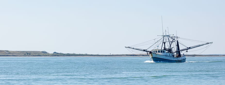 Old fishing boat navigating the Brazos Santiago Pass from the Laguna Madre into the Gulf of Mexico
