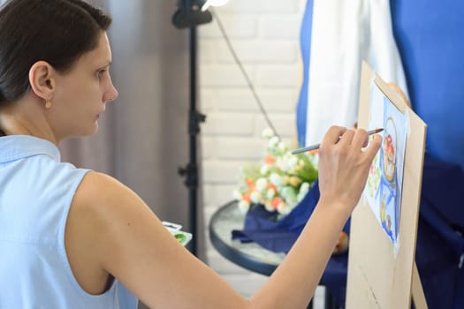 Girl focuses on still life in watercolor studio