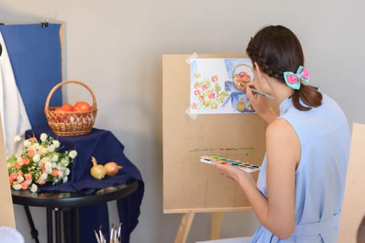 artist draws still life watercolor paints on easel