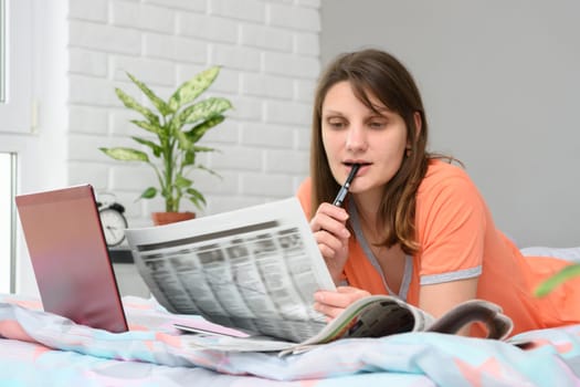 A girl looks in the newspaper job ads