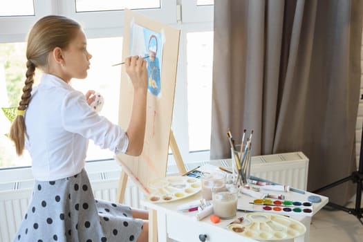 Girl gently draws still life sitting in front of a large light window