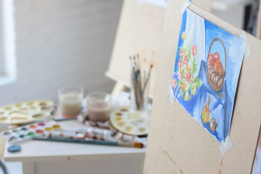 artist's workplace with an easel on which hangs still life