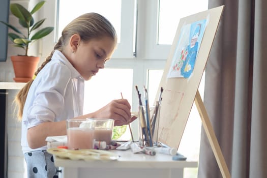 Young artist draws in the studio behind an easel