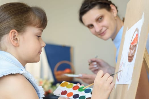 Teacher looks at how a student draws still life