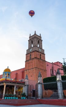 Hot air balloon flying over La Santa Escuela de Cristo early in the morning, in San Miguel de Allende, Guanajuato, Mexico