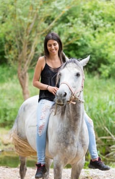 Happy young woman with her horse and strolling