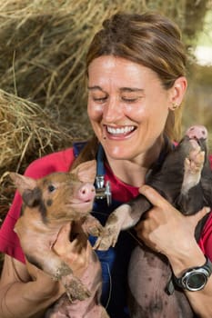 Veterinary with two pigs laughing after conducting an examination on the farm