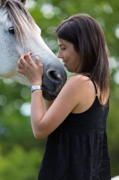 Happy young woman with her horse and strolling