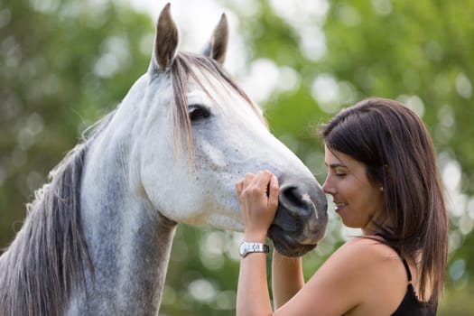 Happy young woman with her horse and strolling