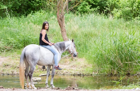 Happy young woman with her horse and strolling