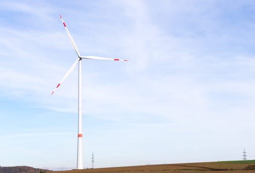 The windmill on a field with blue sky