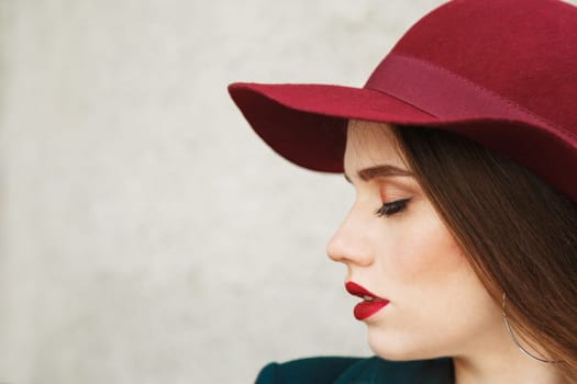 Young beautiful Woman Profile Portrait. Woman in a red hat on her head, Beautiful Face and soft Skin