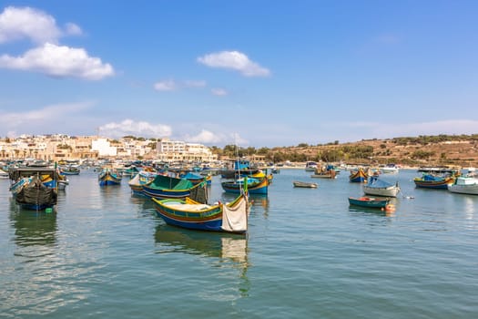 Marsaxlokk village harbor of Malta, Mediterranean traditional colorful boats luzzu. Island of Malta.