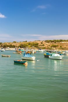 Marsaxlokk village harbor of Malta, Mediterranean traditional colorful boats luzzu. Island of Malta.