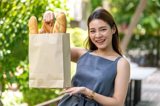 Portrait of attractive and smile asian woman holding grocery bag buy from supermarket. Food and drink and consumerism buying concept.