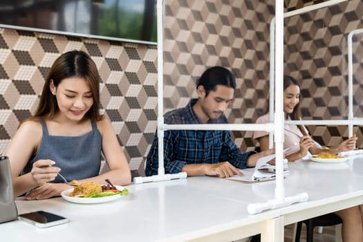 Restaurant customers have a seat with table shield partition for social distancing to reduce infection of coronavirus covid-19 pandemic. Restaurant new normal lifestyle.