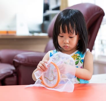 Asian girl child sewing in living room at home as home schooling while city lockdown because of covid-19 pandemic across the world. Home Scholling prepare for Preschool concept.