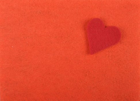Heart of felt on red background