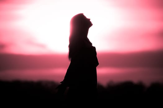 Silhouette in front of sunset or sunrise in summer nature. Symbol for healing burnout therapy, wellness relaxation or resurrection.