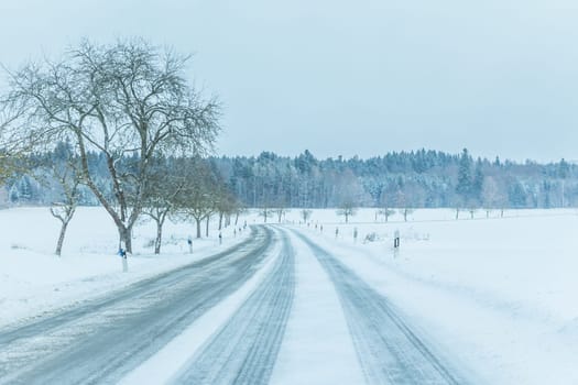 The street track is slick frozen. High dangerous risk of accident through blizzard snowstorm and severe christmas time season weather.