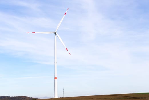 The windmill on a field with blue sky