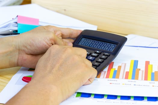 Employees use office calculators with documents of income, expenses, concept of life at work.