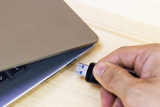 hand man hold Flash drive connect to USB port plug-in computer laptop for transfer data and backup business concept