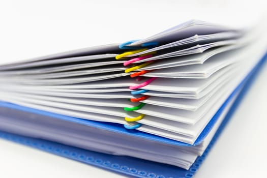 close up of Stack of papers files piles of unfinished documents achieves with paper clips .