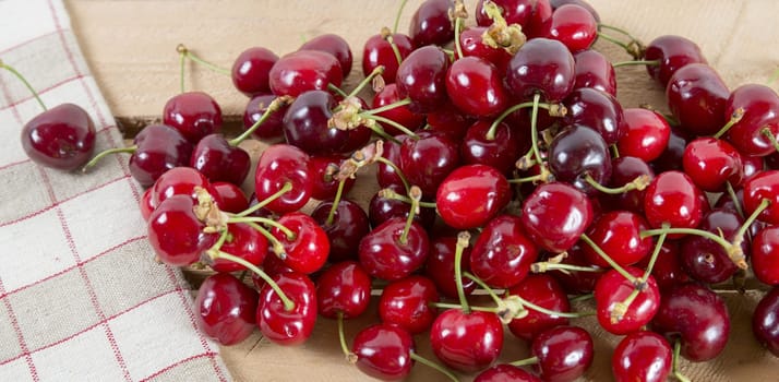 a bunch of cherries on the wooden table