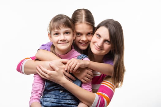 Two girls and a mother of European appearance happily look at the frame