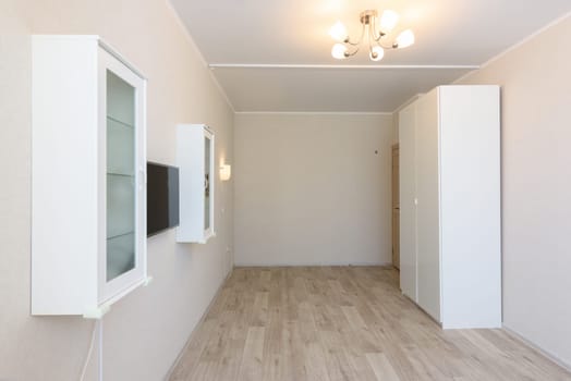 The interior of the room is under the bedroom, there are cabinets on both sides, a TV is hanging