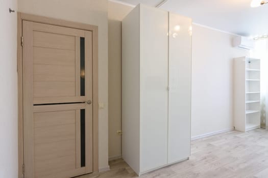 Fragment of the interior of the bedroom, entrance door and wardrobes