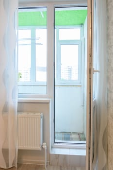 Exit to a glazed balcony from a room in a multi-storey building