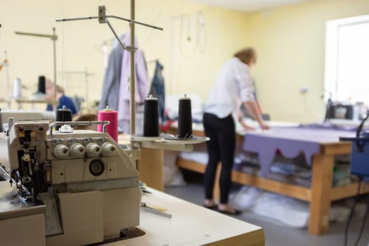 sewing equipment in the workshop and seamstress in the background