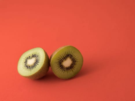 Close-up of a kiwi cut in half. Isolated on a red background.