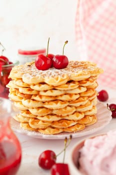 Homemade sweet waffles with fresh cherries and cream