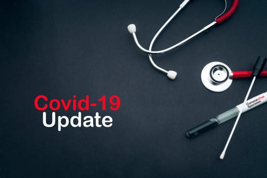 COVID-19 UPDATE text with stethoscope and medical swabs on black background. Covid -19 or Coronavirus Concept