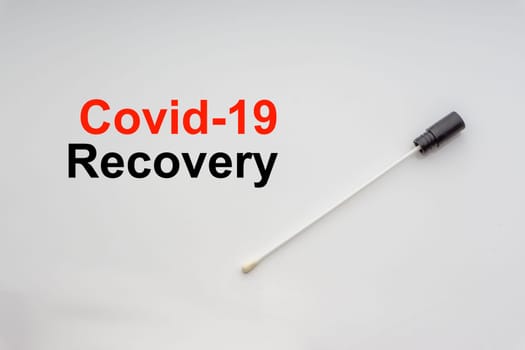 COVID-19 RECOVERY text with medical swab on white background. Covid or Coronavirus Concept