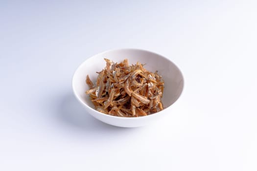 Fried anchovies in bowl close up with selective focus and crop fragment