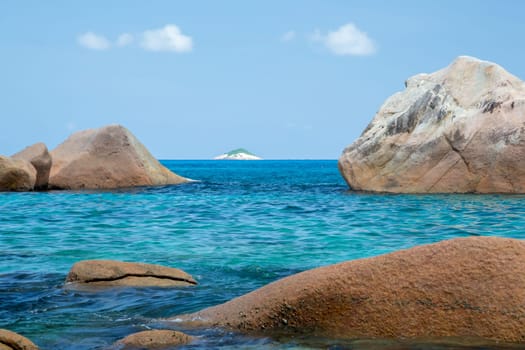 The beach of the Seychelles with blue water and stones